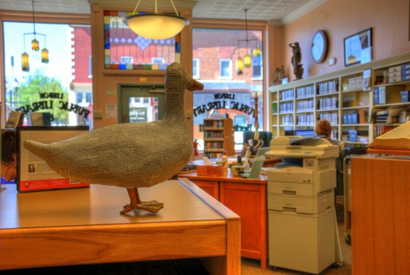 a paper mache duck looks over at Amy as she works